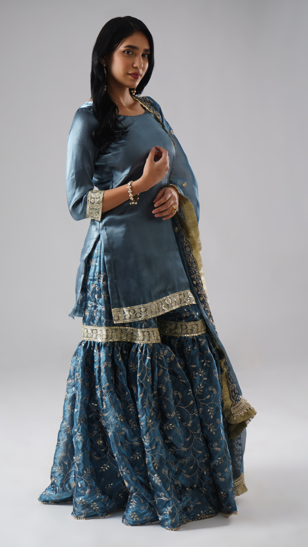 Right side view of model wearing Zahrat’s Tehzeeb-e-Aab teal blue gharara set, showcasing the complete ensemble.