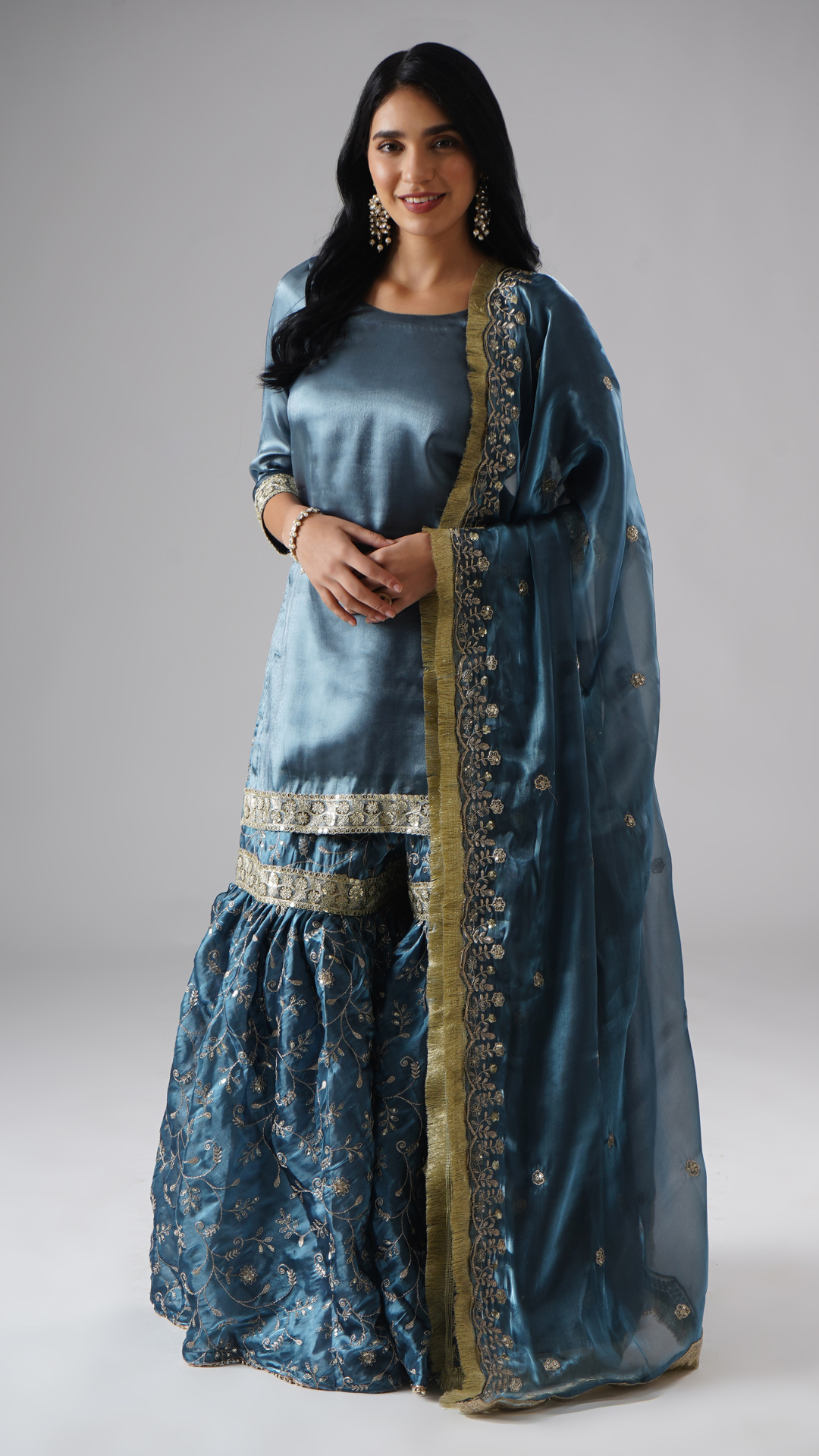 Model wearing Zahrat’s Tehzeeb-e-Aab gharara in teal blue, front view showcasing the complete set with gharara, kurta, and dupatta.