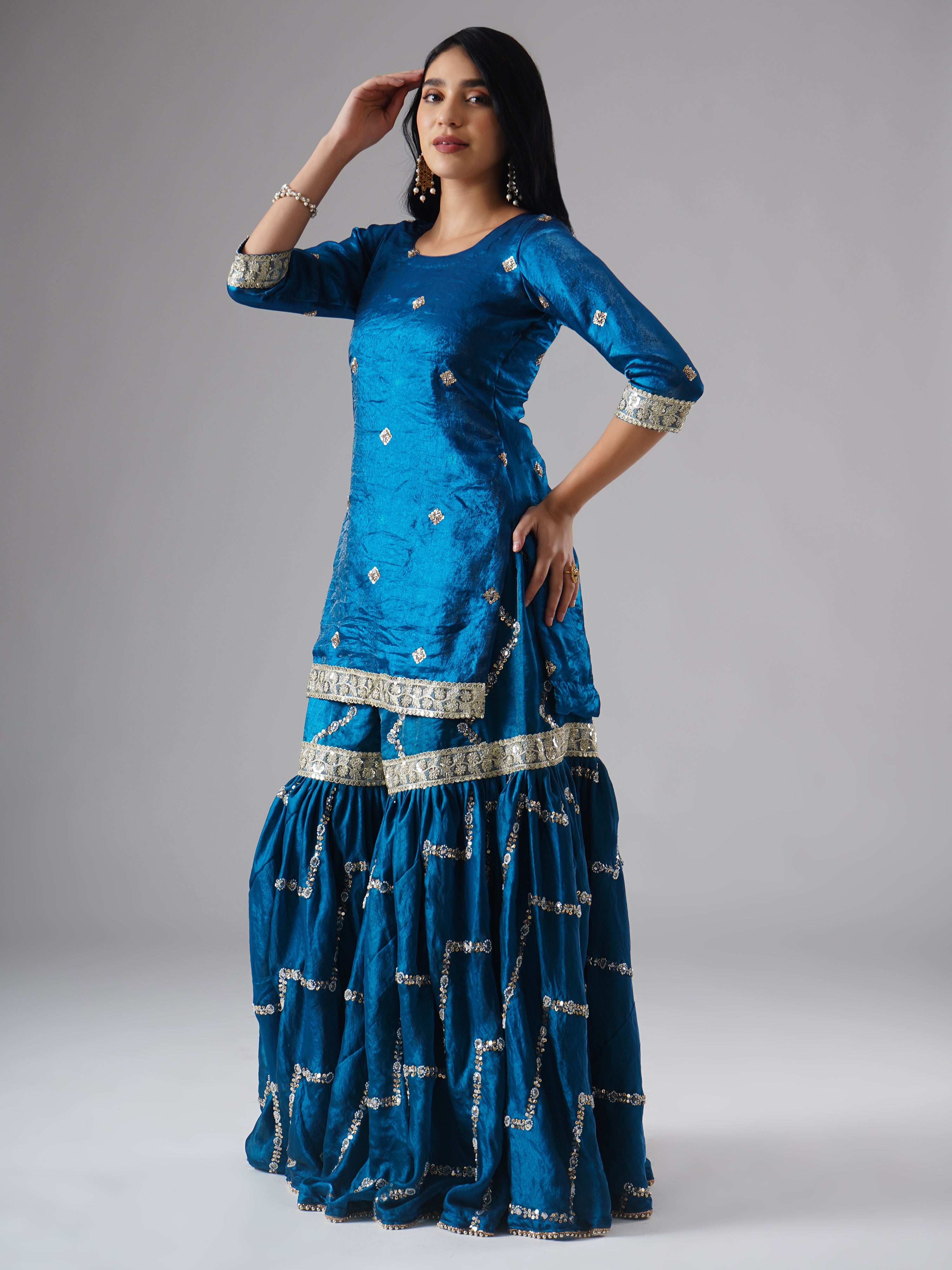 Side view of model wearing Zahrat’s Neelafshan – The Teal Sapphire gharara set without dupatta, highlighting the gharara flare and kurta.
