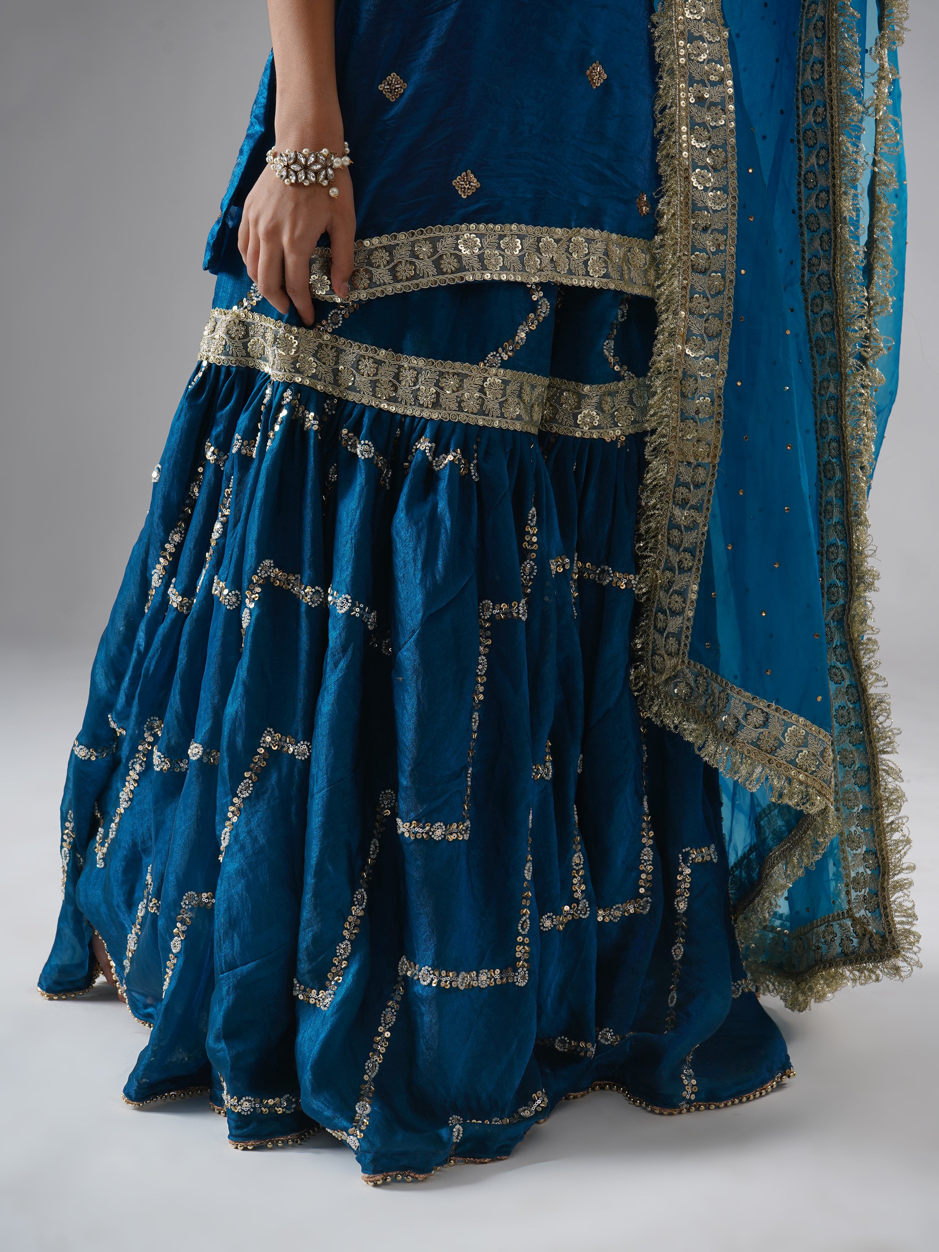 Close-up of the gharara from Zahrat’s Neelafshan – The Teal Sapphire gharara set, highlighting fabric, flare, and detailing.