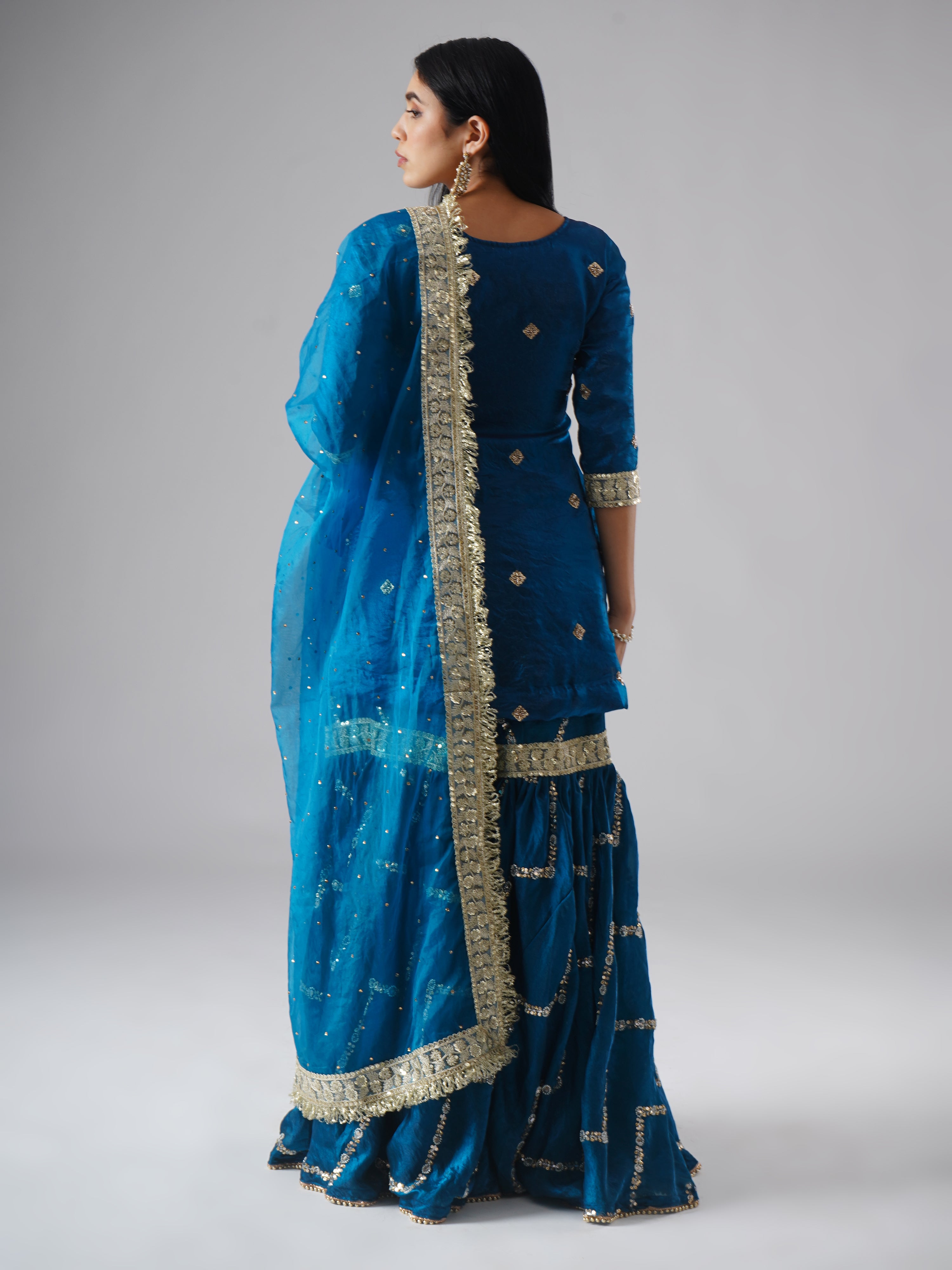 Model styled in the Neelafshan – The Teal Sapphire gharara set by Zahrat, back view highlighting the full outfit and draped dupatta.