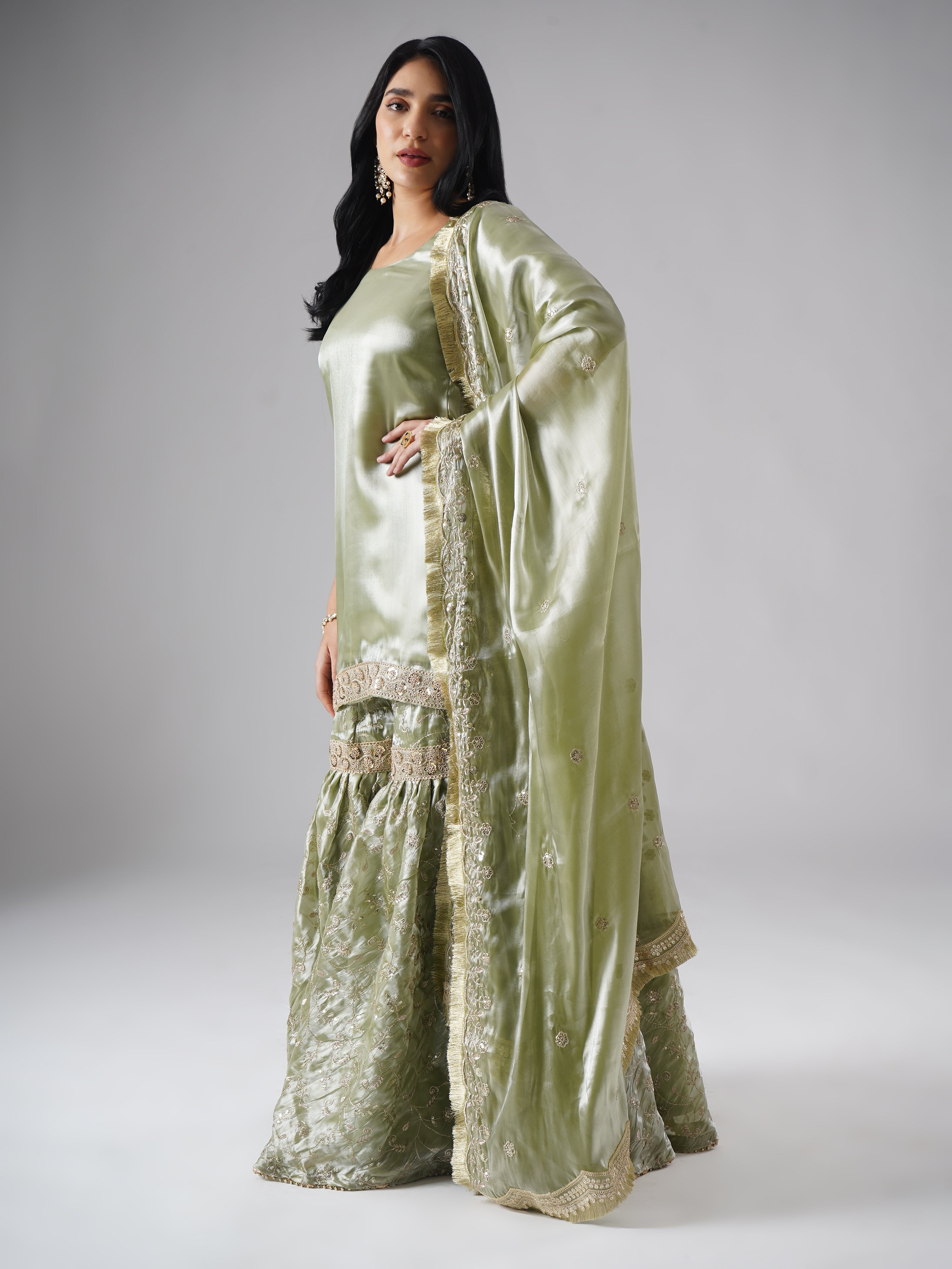Model styled in the Mehr-e-Zaytuni – The Olive Whisper gharara set by Zahrat, left side view highlighting the draped dupatta and full outfit.