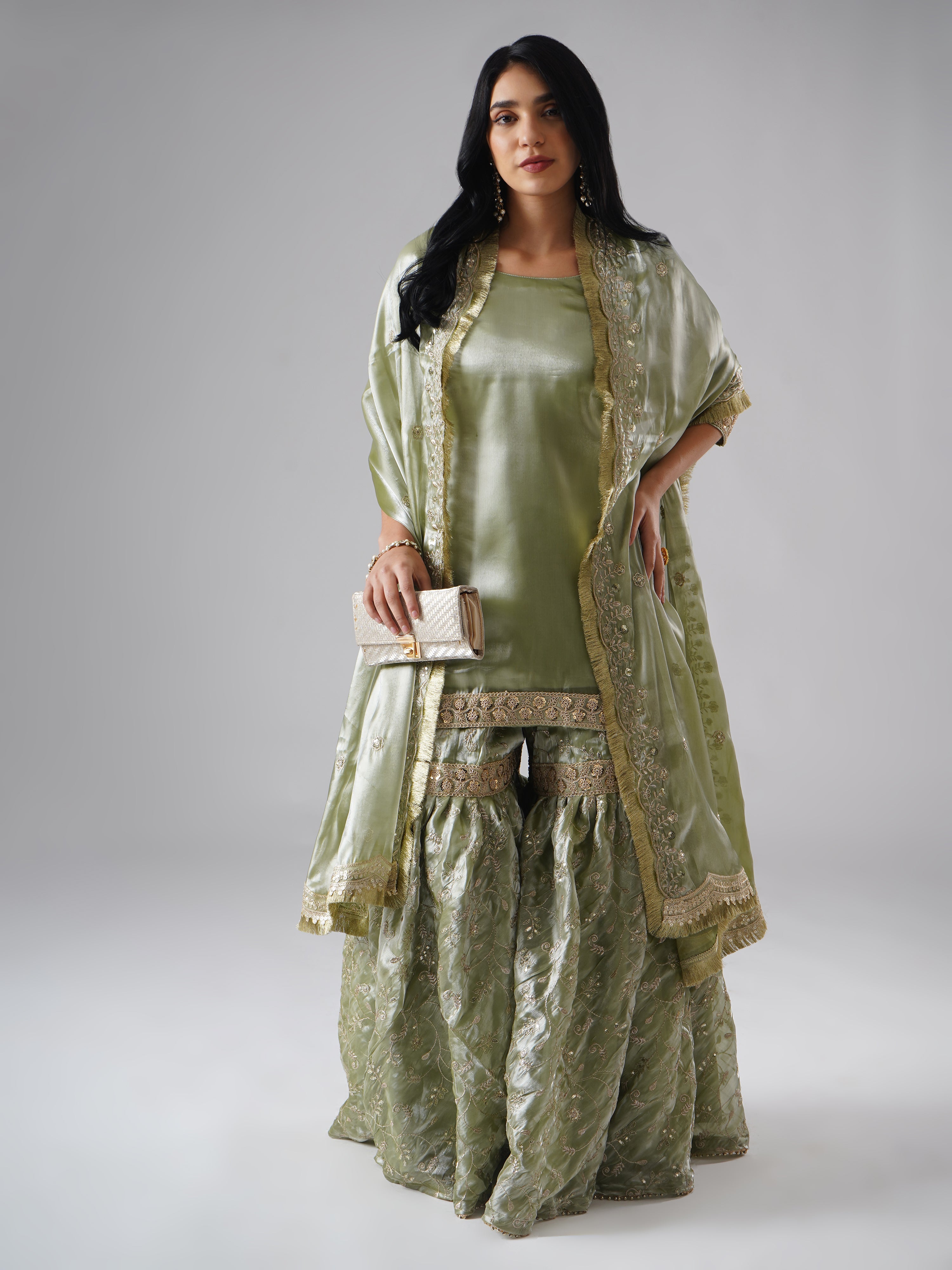 Full outfit of the Mehr-e-Zaytuni – The Olive Whisper gharara set by Zahrat, styled with a clutch, highlighting the gharara, kurta, dupatta, and accessories.