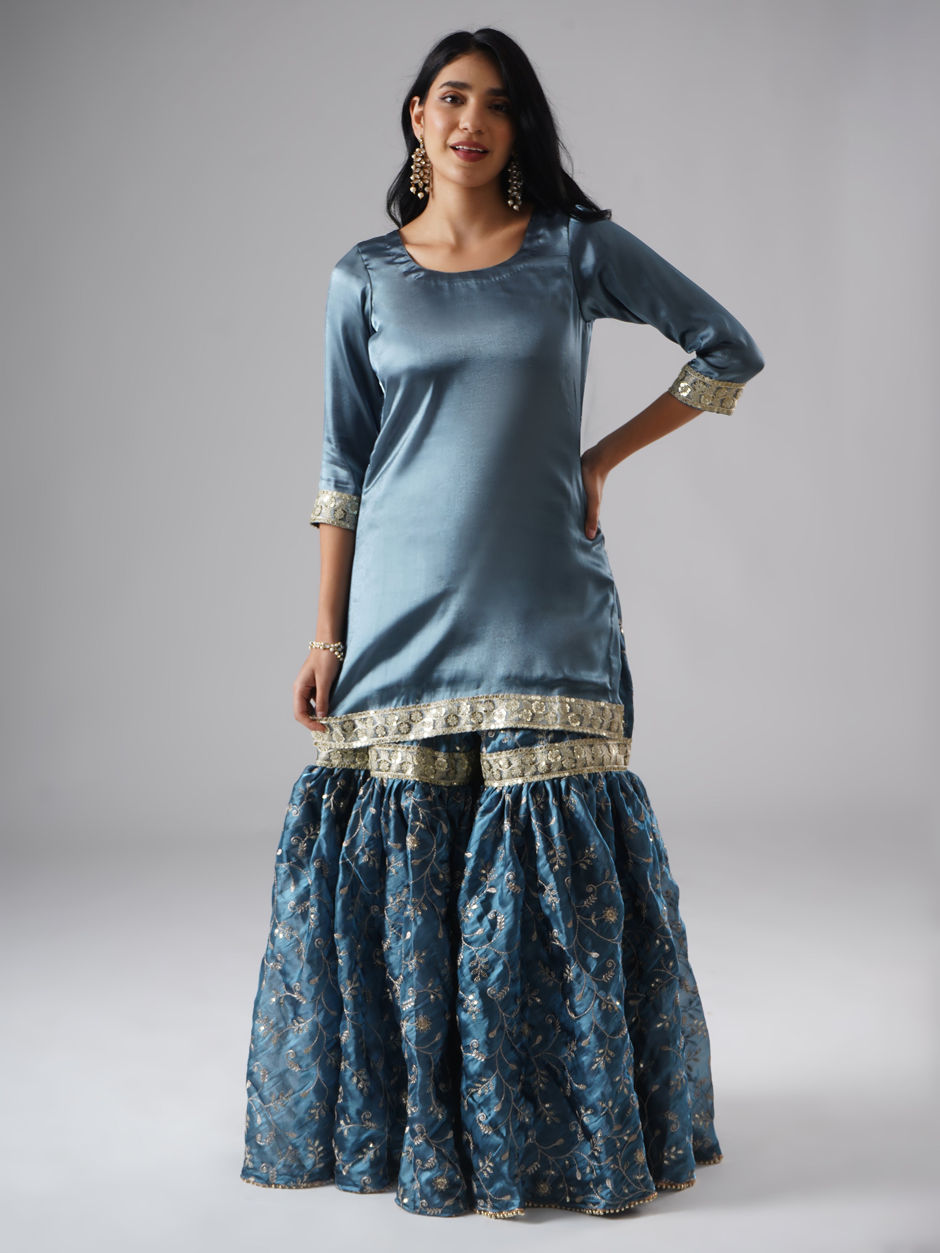 Front view of model wearing Zahrat’s Tehzeeb-e-Aab teal blue gharara set, showcasing the gharara and kurta without the dupatta.