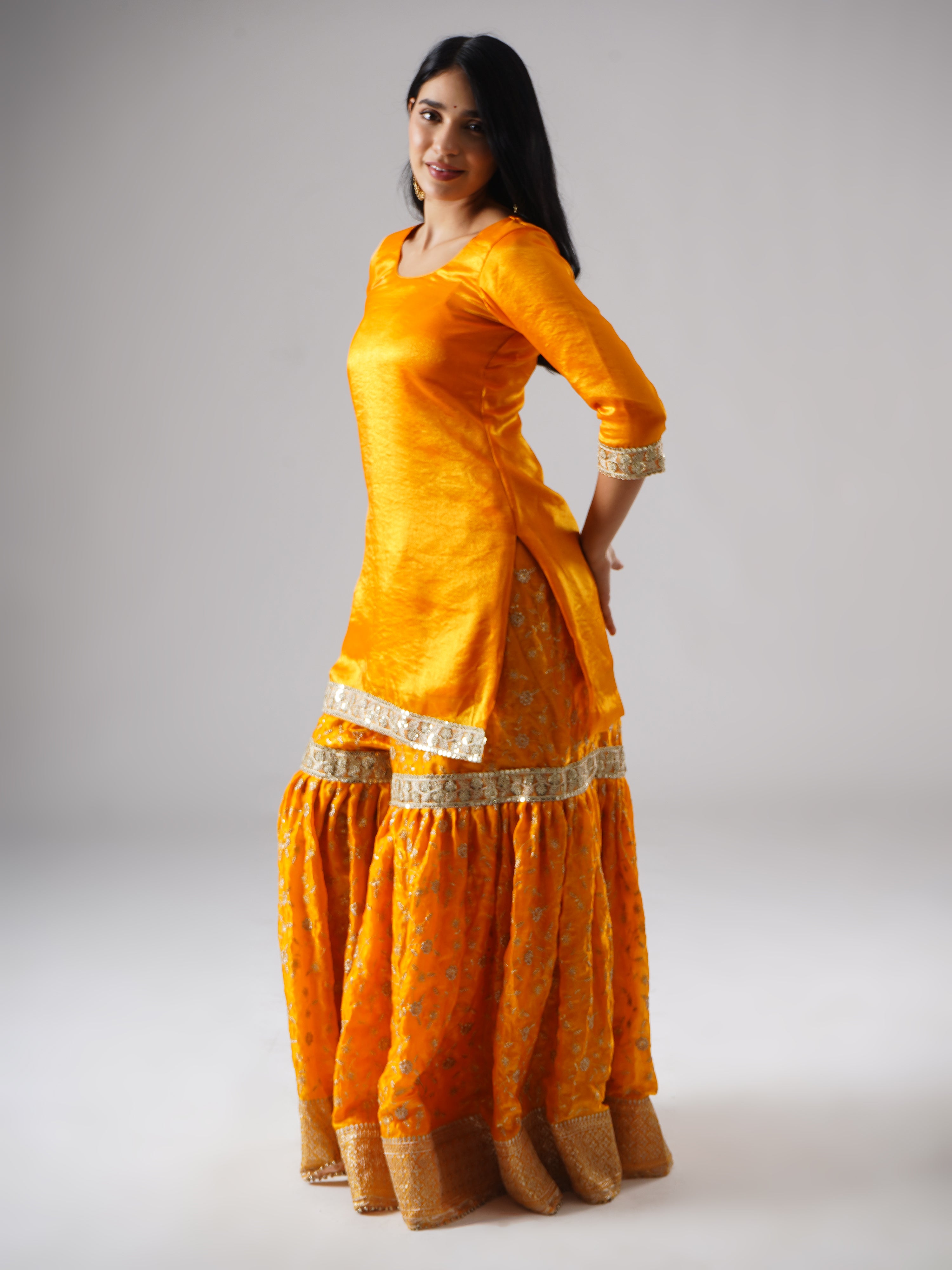 Side view of model wearing Zahrat’s Mehrigold gharara set without dupatta, highlighting the gharara flare and kurta.