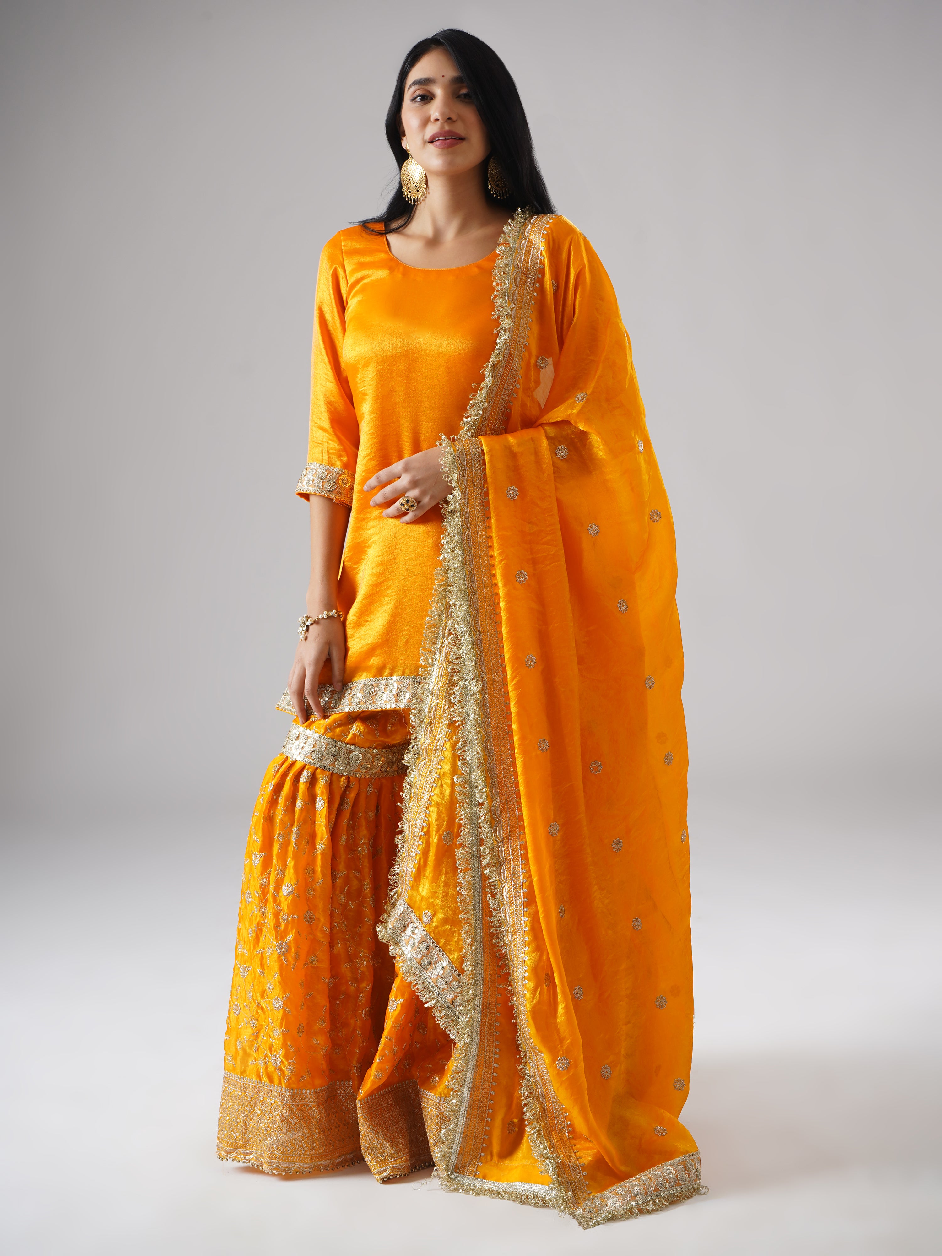 Front view of model in the Mehrigold gharara set by Zahrat, styled at a slight angle to showcase the dupatta along with the complete outfit.