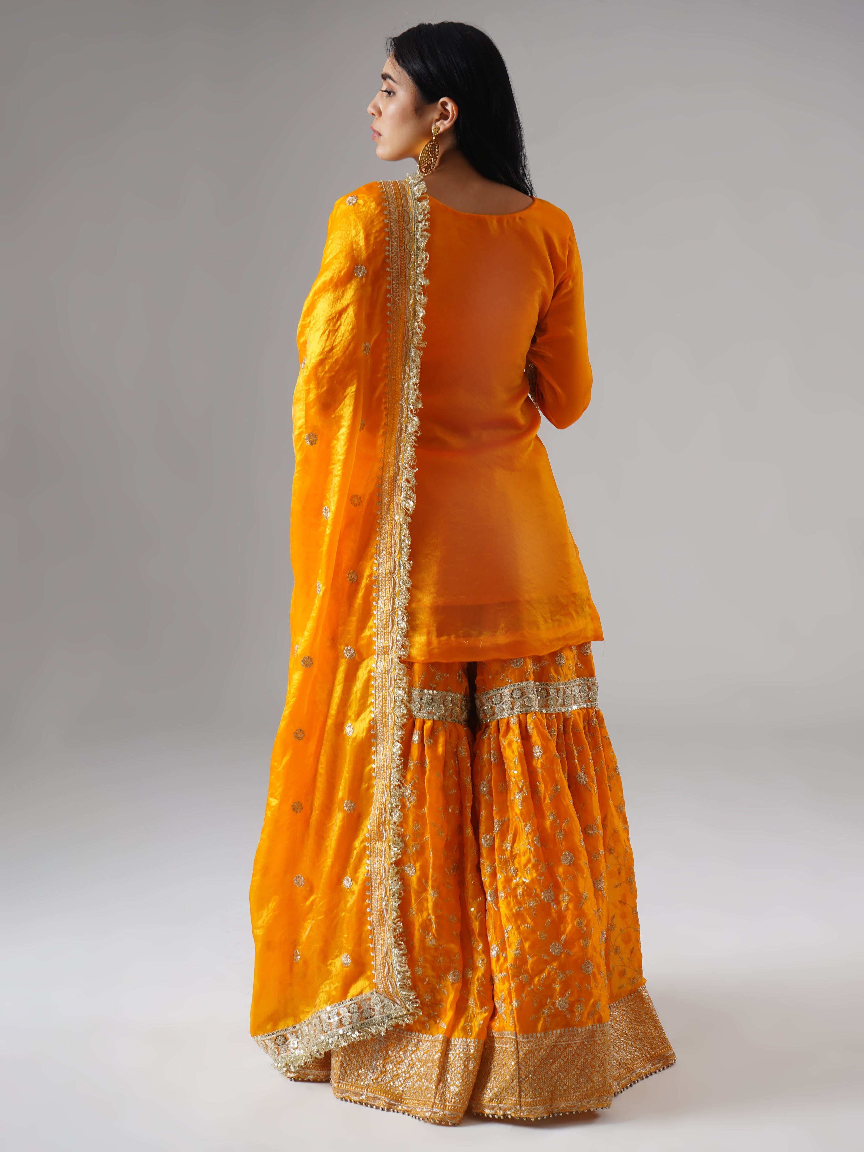 Model styled in the Mehrigold gharara set by Zahrat, back view highlighting the full outfit and dupatta drape.