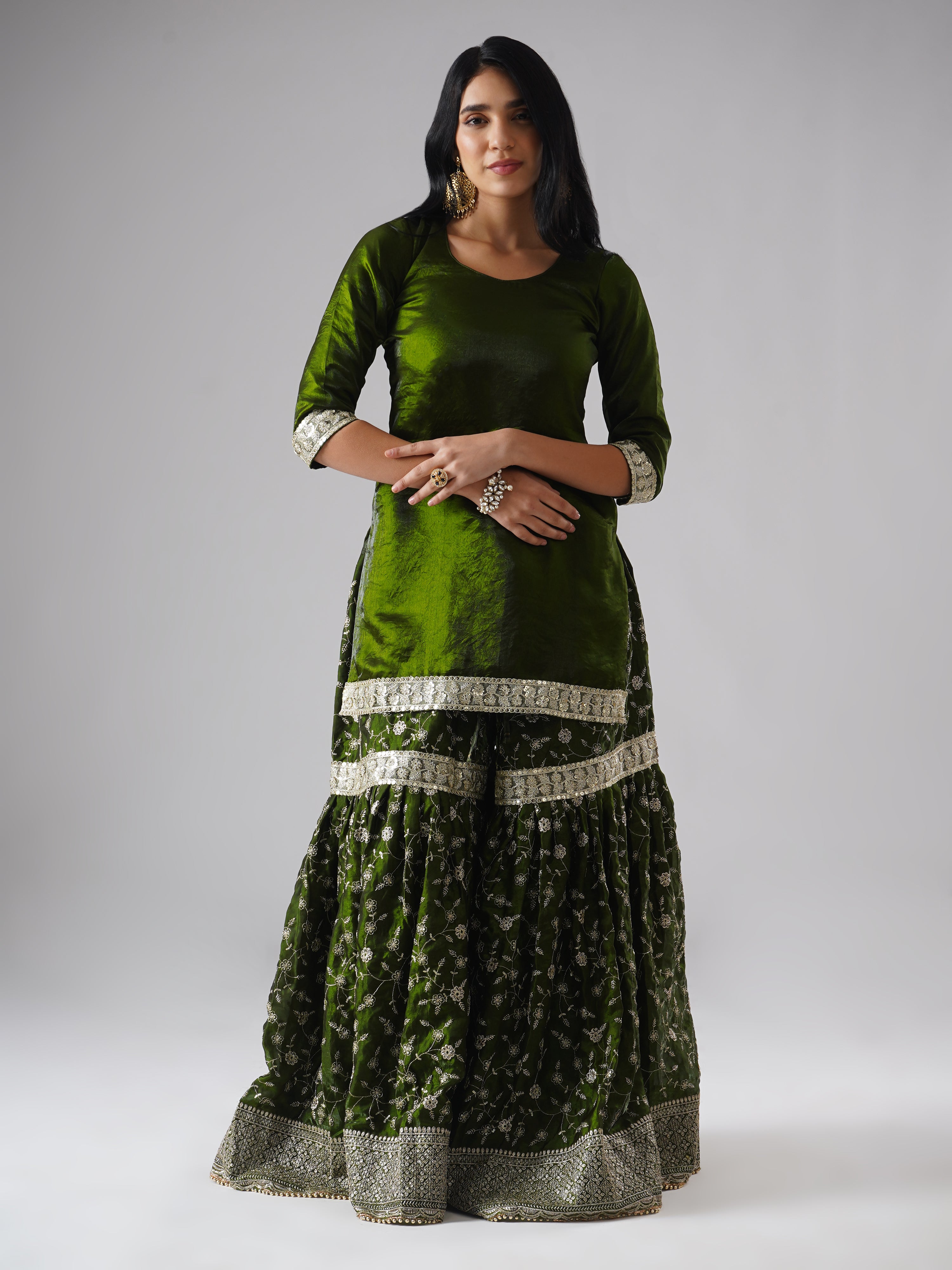 Front view of model wearing Zahrat’s Khushrang Henna jewel-toned henna green gharara set, showcasing the gharara and kurta without the dupatta.