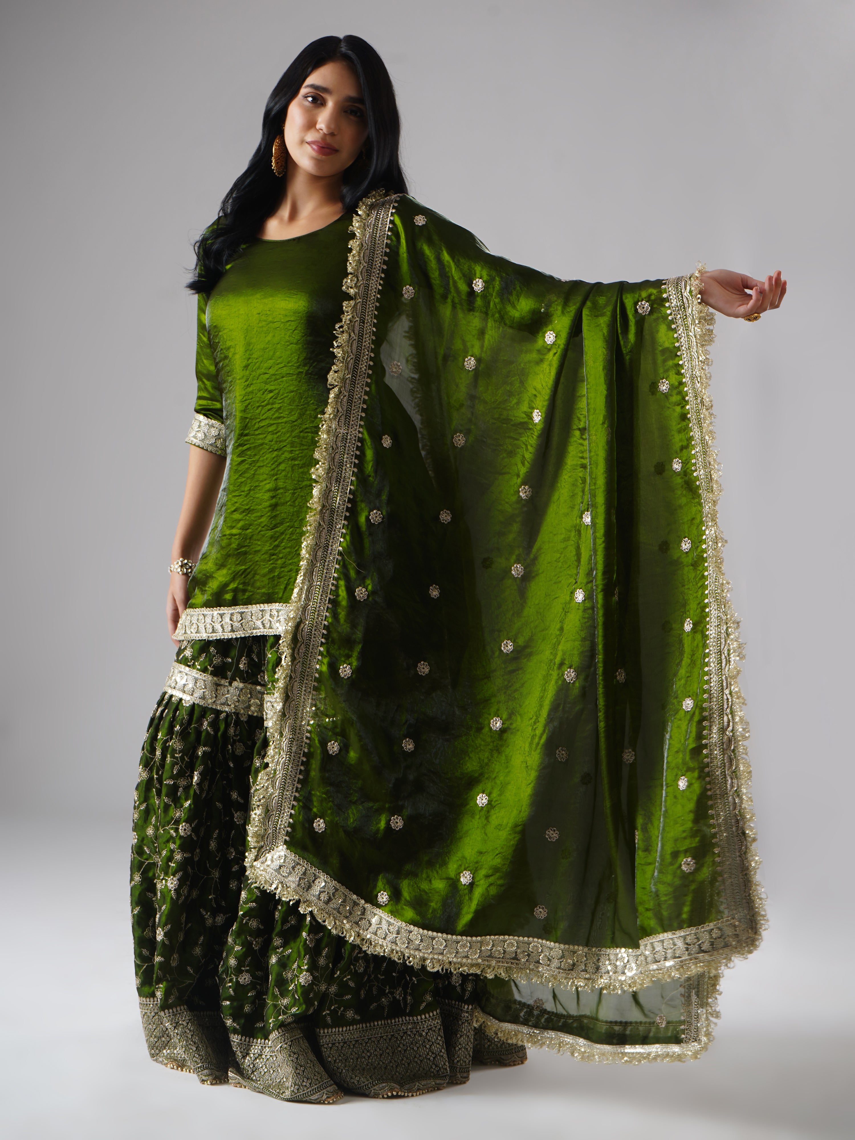 Model styled in the Khushrang Henna Gharara by Zahrat, showcasing the dupatta detailing against the full outfit in henna green.