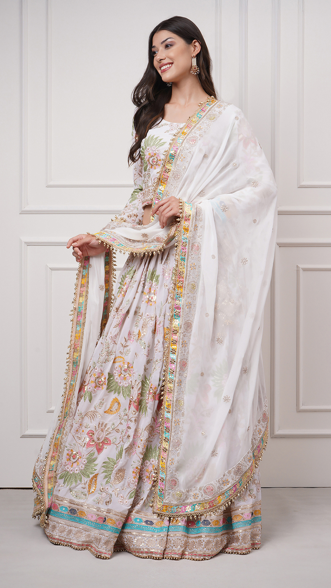 Left side view of a model wearing Eira Bloom Lehenga Set - Zahrat White Embroidered Lehenga 