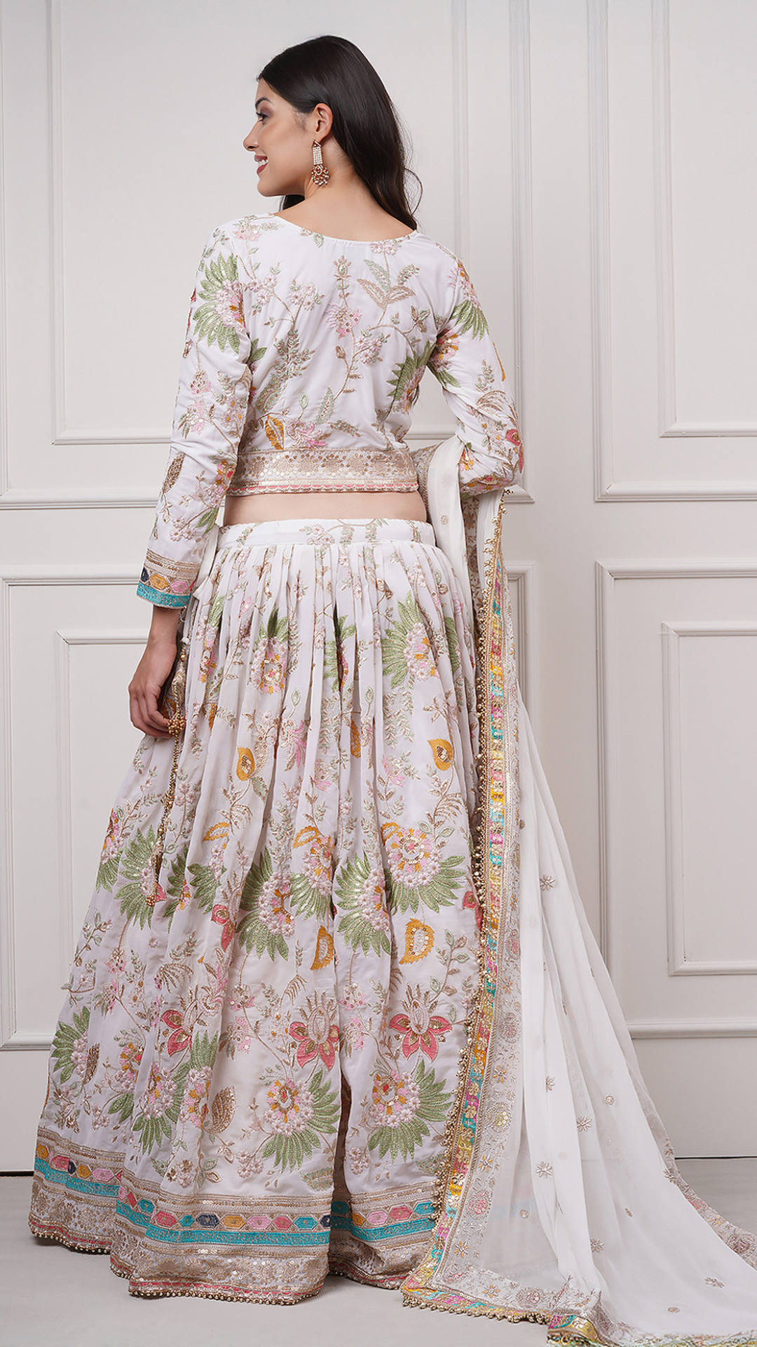 Back side view of a model wearing Eira Bloom Lehenga Set - Zahrat White Embroidered Lehenga 
