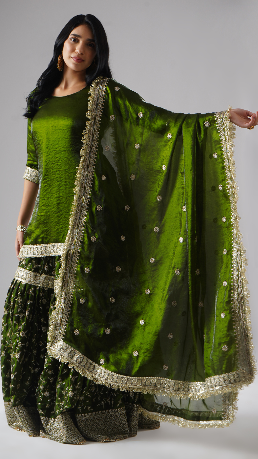 Model styled in the Khushrang Henna Gharara by Zahrat, showcasing the dupatta detailing against the full outfit in henna green.