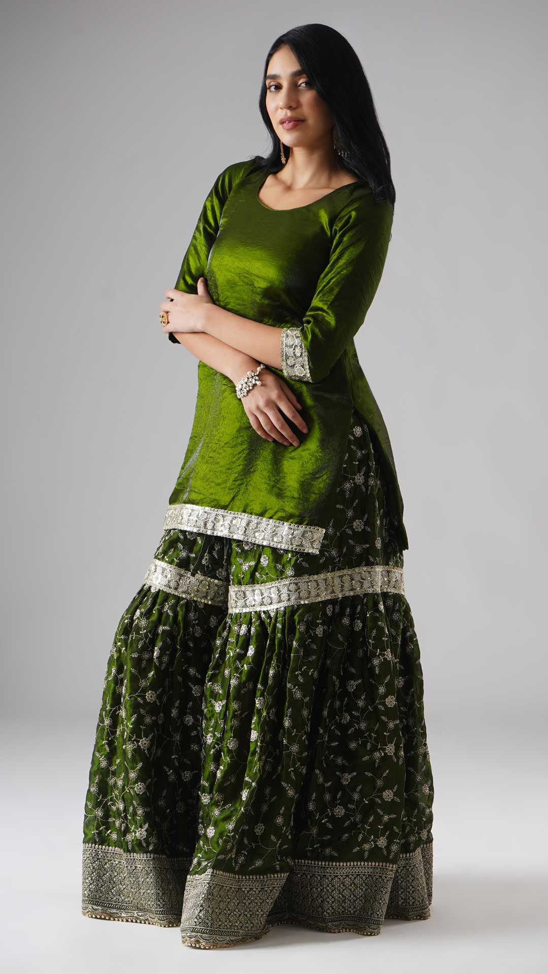 Side view of model wearing Zahrat’s Khushrang Henna jewel-toned henna green gharara set without dupatta, highlighting the gharara flare and kurta.