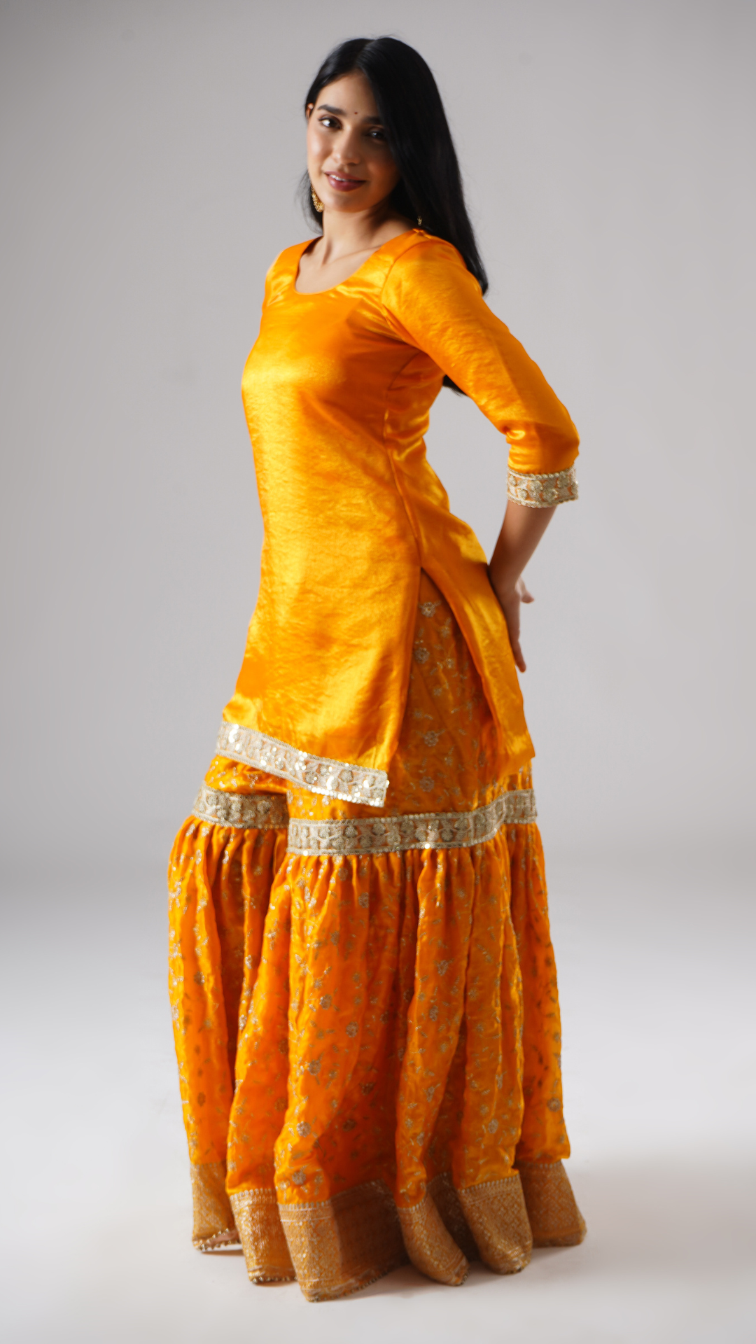 Side view of model wearing Zahrat’s Mehrigold gharara set without dupatta, highlighting the gharara flare and kurta.