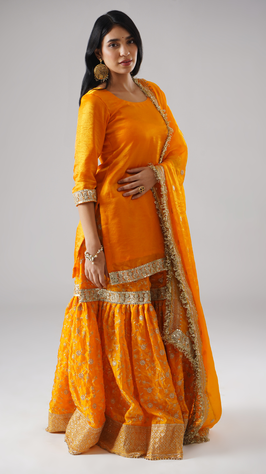 Right side view of model wearing Zahrat’s Mehrigold gharara set, showcasing the complete ensemble with gharara, kurta, and dupatta.