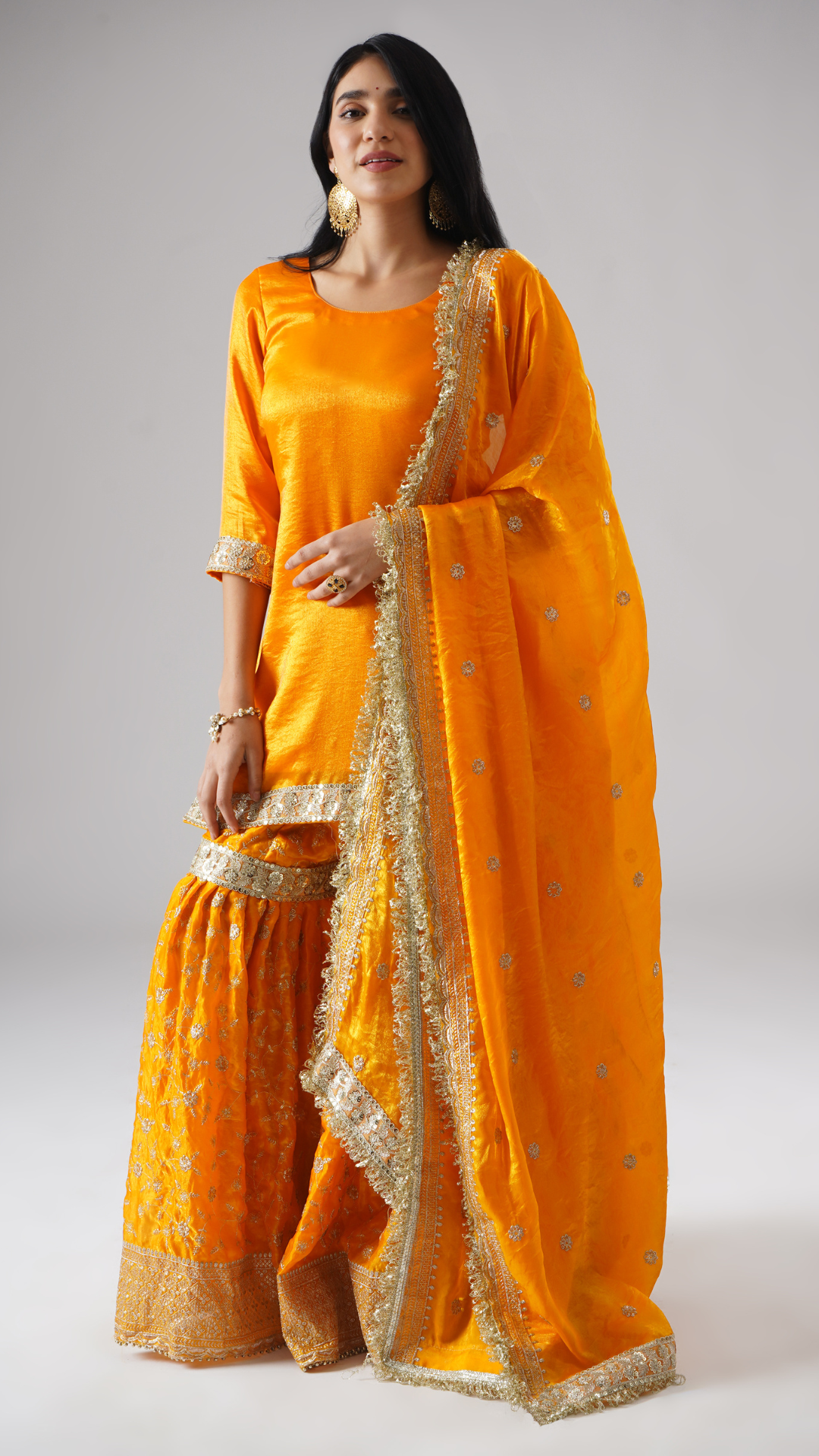 Front view of model in the Mehrigold gharara set by Zahrat, styled at a slight angle to showcase the dupatta along with the complete outfit.