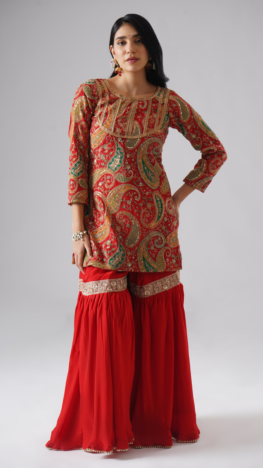 Front view of model wearing Zahrat’s Mehroza crimson red gharara set, showcasing the gharara and kurta without the dupatta.