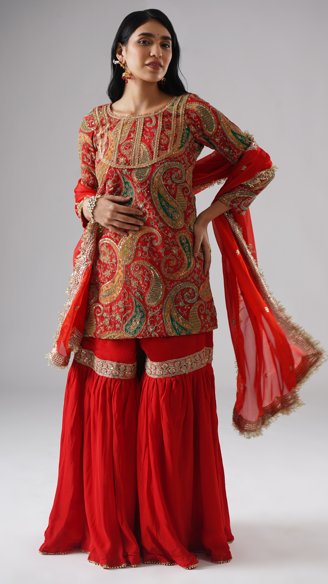 Model wearing Zahrat’s Mehroza crimson red gharara set, alternate view showcasing the dupatta styled differently and the full ensemble.