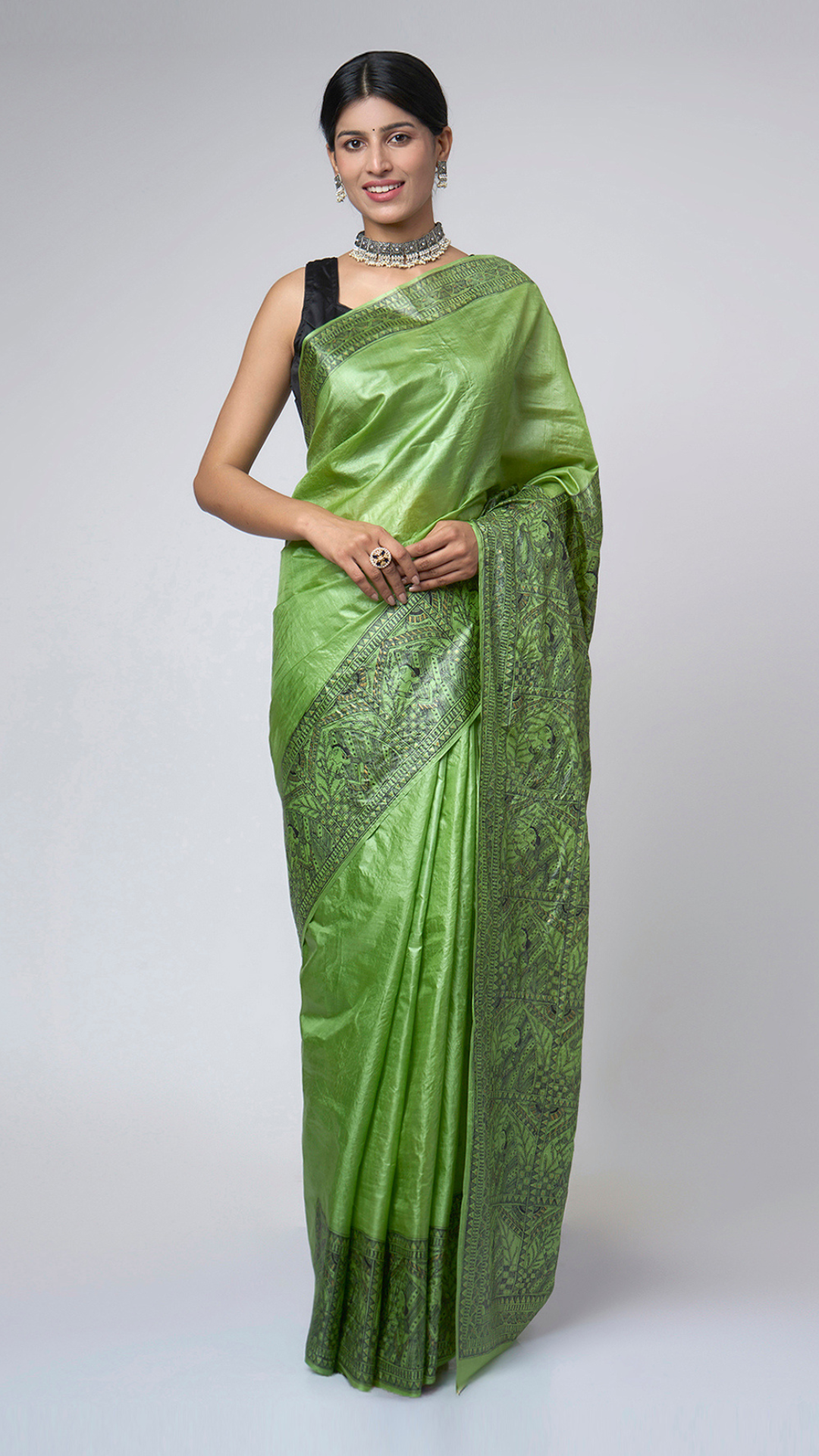 Model wearing Naqsh-e-Zumurrud emerald Madhubani Tussar silk saree with elegant front drape and intricate hand-painted heritage motifs with broad artistic border.