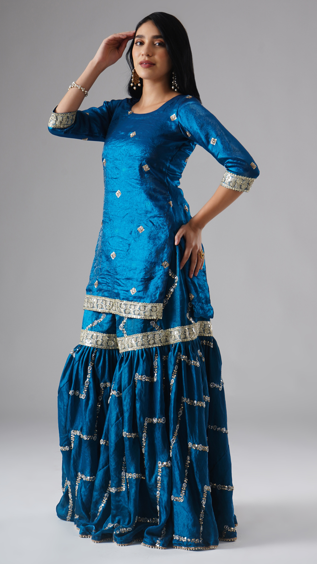 Side view of model wearing Zahrat’s Neelafshan – The Teal Sapphire gharara set without dupatta, highlighting the gharara flare and kurta.