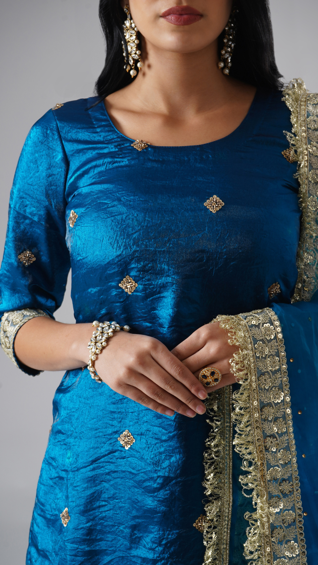 Close-up of Zahrat’s Neelafshan – The Teal Sapphire gharara set, highlighting the kurta fabric texture and dupatta design details.