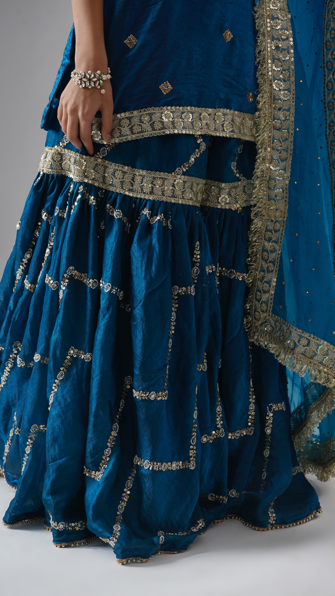 Close-up of the gharara from Zahrat’s Neelafshan – The Teal Sapphire gharara set, highlighting fabric, flare, and detailing.