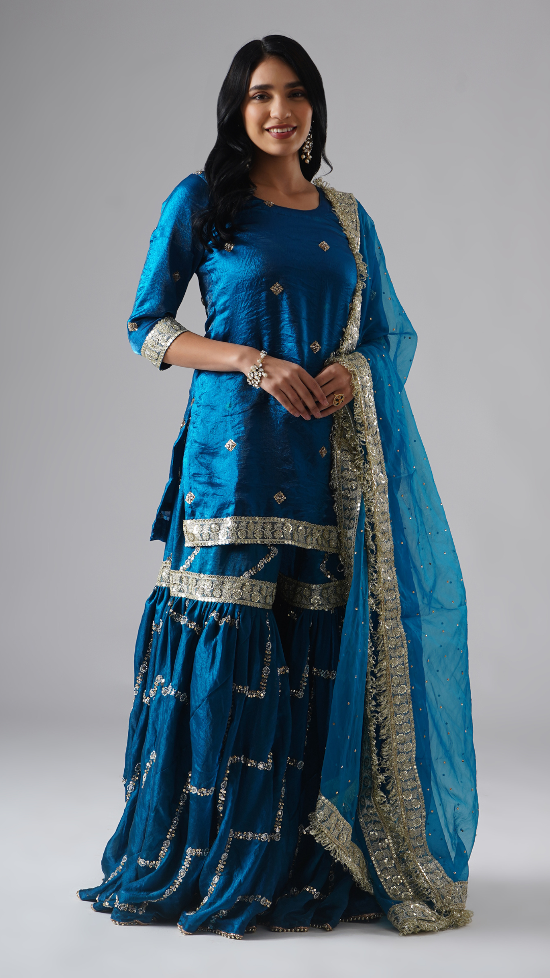 Model styled in the Neelafshan – The Teal Sapphire gharara set by Zahrat, front view highlighting the full outfit including gharara, kurta, and dupatta.