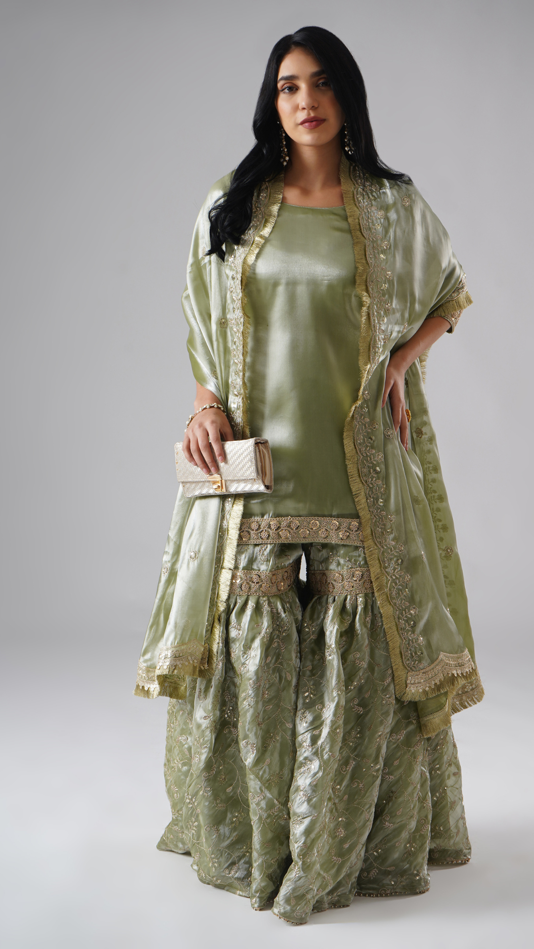 Full outfit of the Mehr-e-Zaytuni – The Olive Whisper gharara set by Zahrat, styled with a clutch, highlighting the gharara, kurta, dupatta, and accessories.