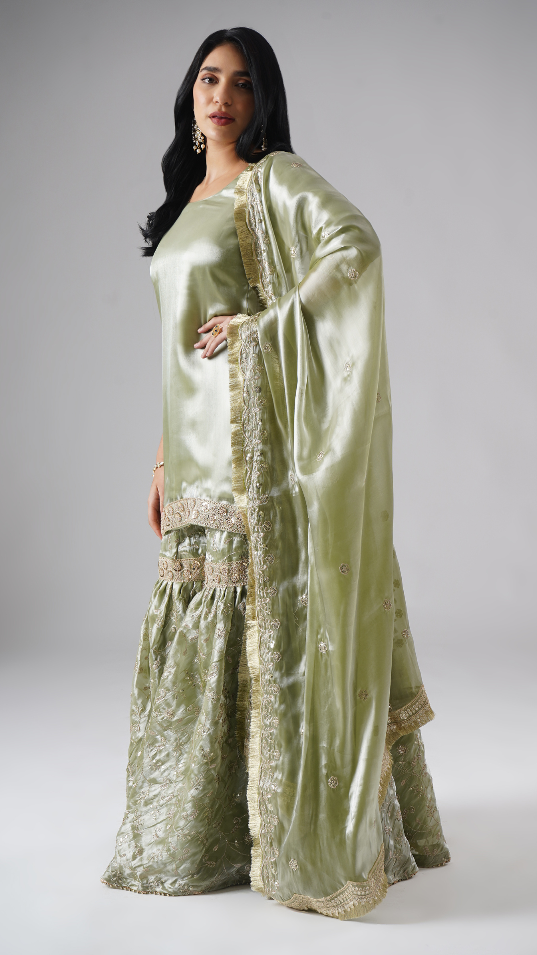 Model styled in the Mehr-e-Zaytuni – The Olive Whisper gharara set by Zahrat, left side view highlighting the draped dupatta and full outfit.