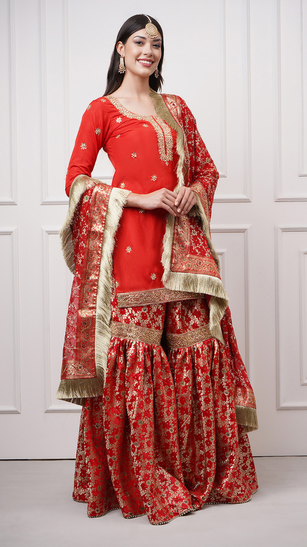 A women models in Surkhnaaz – Red Kimkhwab Bridal Gharara Set by Zahrat