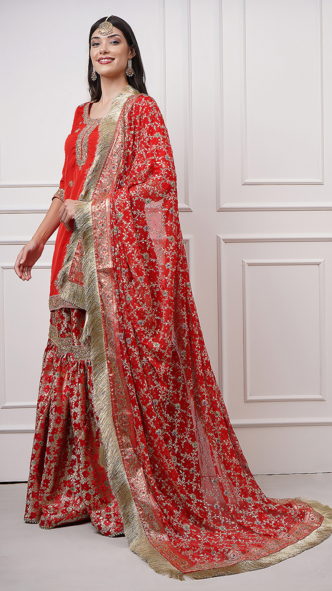 A women models in Surkhnaaz – Red Kimkhwab Bridal Gharara Set by Zahrat featurng the intricate dupatta design.