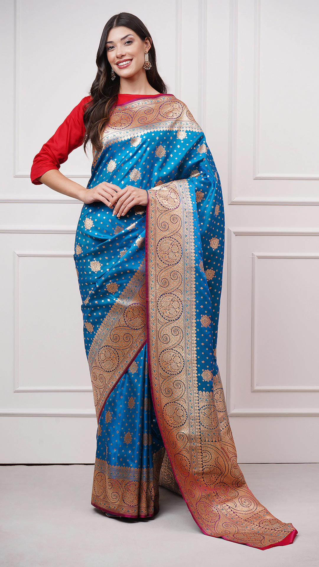 A woman models in Taraani – Midnight Sapphire Saree by Zahrat. A blue and gold Banarasi saree. - front view.