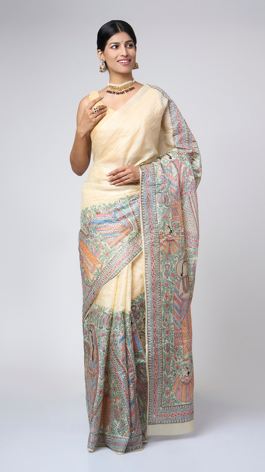 Model wearing Varnika Sand Ivory Madhubani silk saree with an elegant front drape and intricate hand-painted heritage artwork.