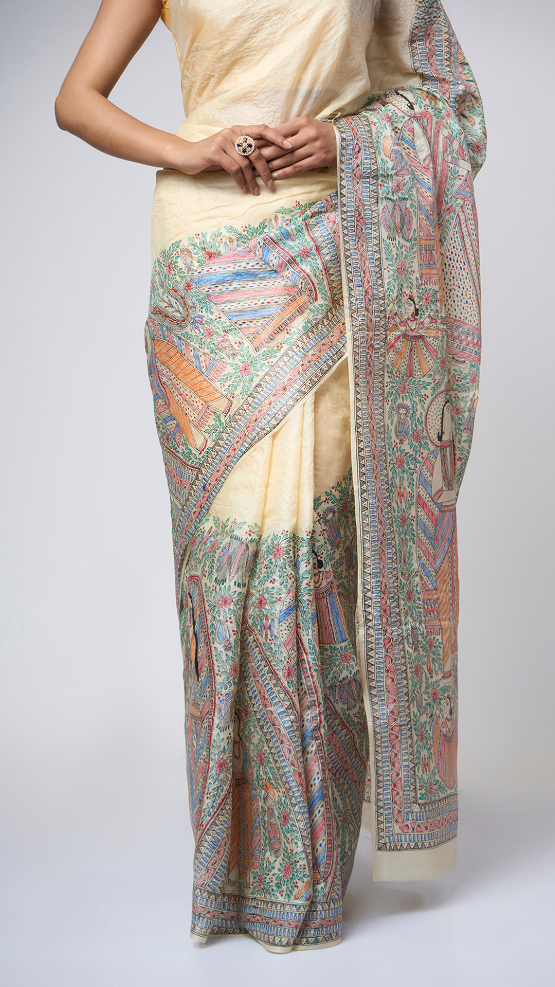 Close-up view of Varnika Sand Ivory Madhubani silk saree highlighting the intricate hand-painted Mithila artwork, fine detailing, and rich artisanal texture on pure silk.
