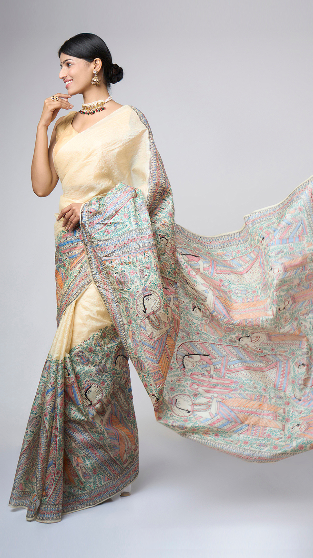 Left side view of Varnika Sand Ivory Madhubani saree showcasing the richly illustrated hand-painted pallu and broad artistic border.