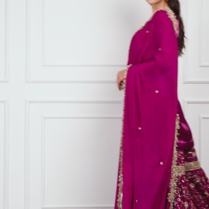 Video of a model wearing the Zahrat Raina – Fuchsia Bloom Gharara Set, walking and twirling to reveal the gharara’s voluminous flare, shimmering gota embroidery, and the graceful movement of the golden-edged dupatta.