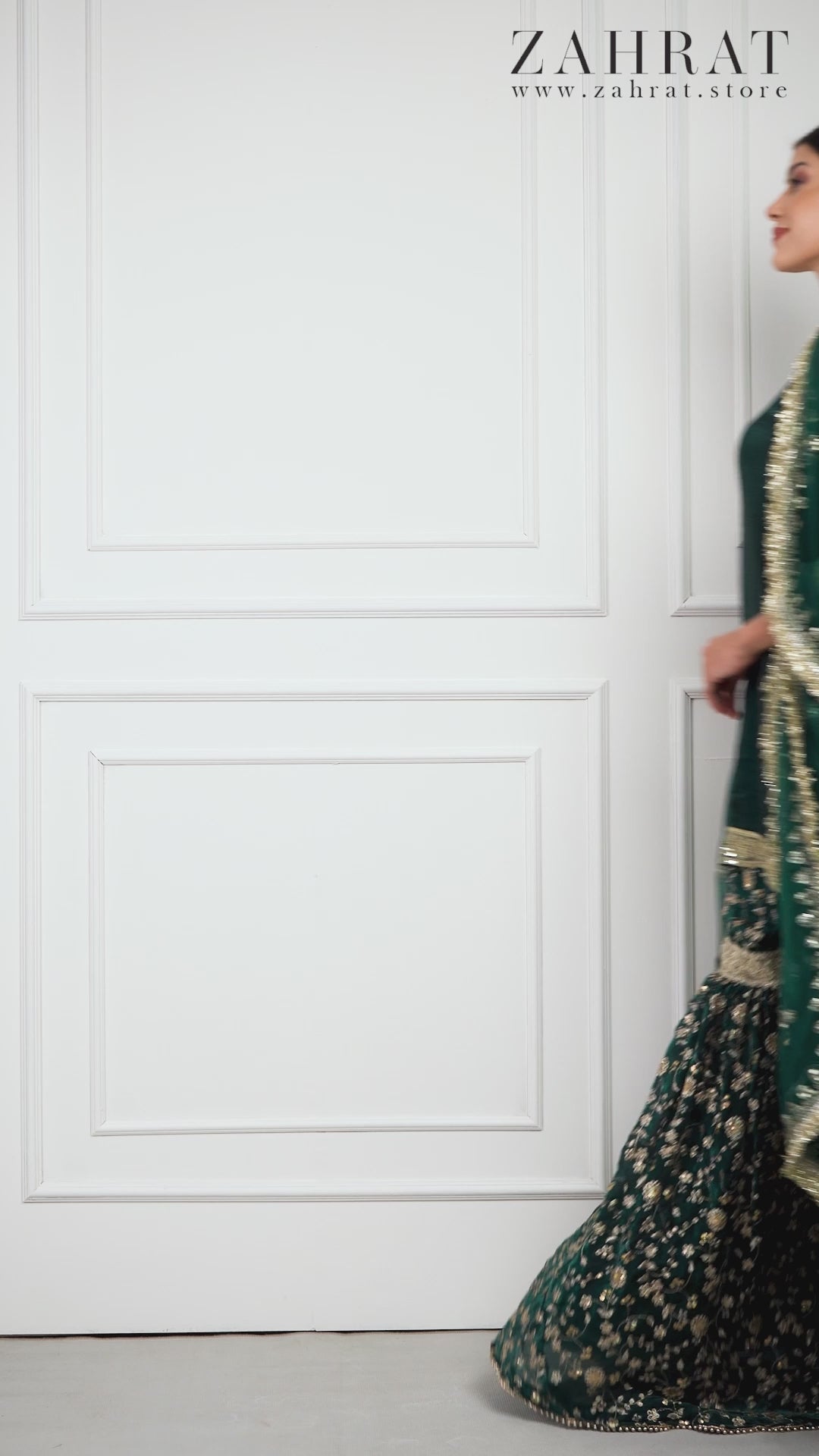 Video of model in Zahrat Zyra – Regal Ivy Gharara Set, twirling to reveal bottle-green flare, gold embroidery, and shimmering dupatta.