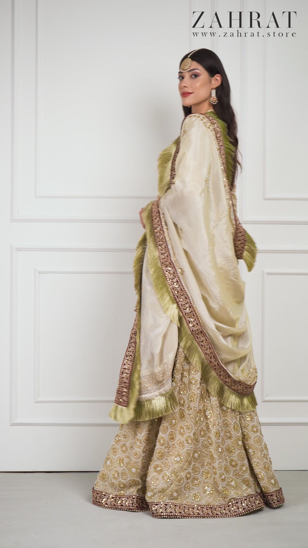 Video of a model wearing the Zahrat Zarafshan Gharara Set, walking and twirling to reveal the gharara’s voluminous flare, shimmering gold embroidery, and the soft flow of the coordinating dupatta.