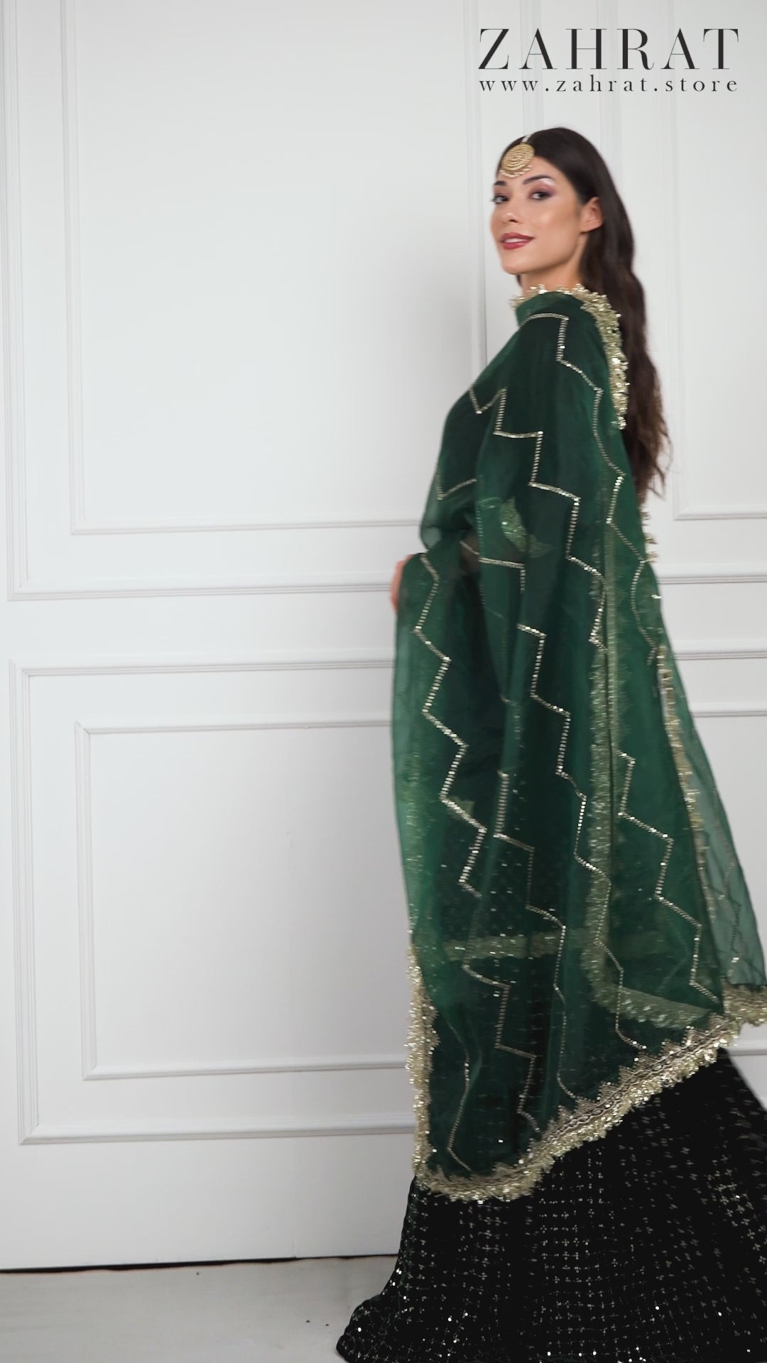 Video of a model wearing the Zahrat Esmeriya Gharara Set, walking and twirling to reveal the gharara’s voluminous flare, shimmering gold embroidery, and soft flow of the coordinating dupatta.