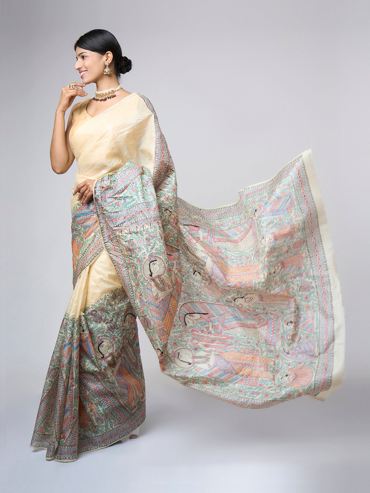 Left side view of Varnika Sand Ivory Madhubani saree showcasing the richly illustrated hand-painted pallu and broad artistic border.