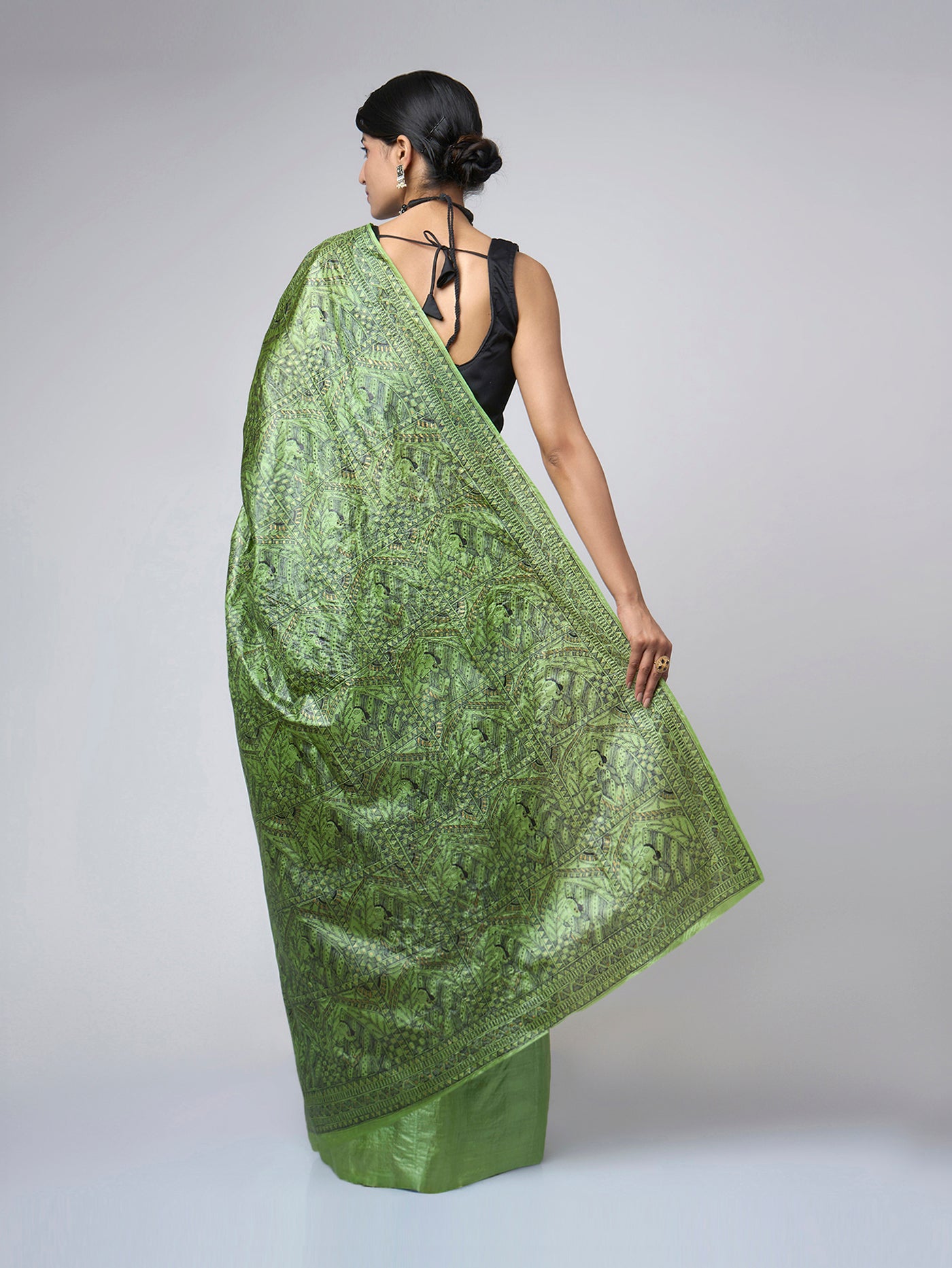 Full back view of Naqsh-e-Zumurrud emerald Madhubani Tussar silk saree featuring the intricately illustrated all-over pallu with traditional storytelling art details.
